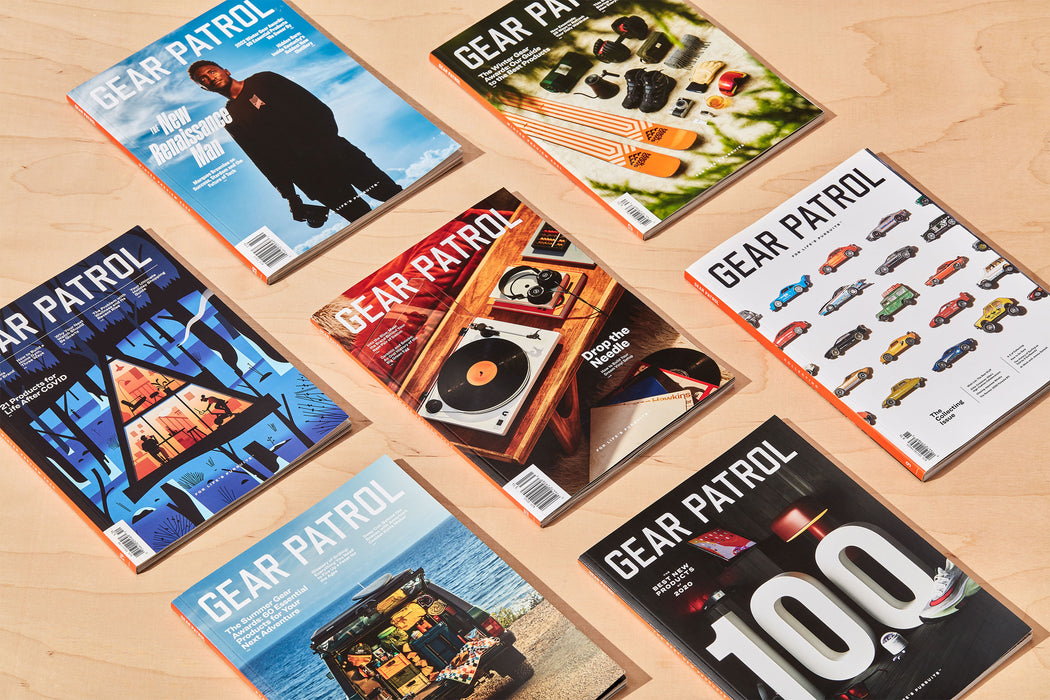 several copies of gear patrol magazine laying flat on a wood table