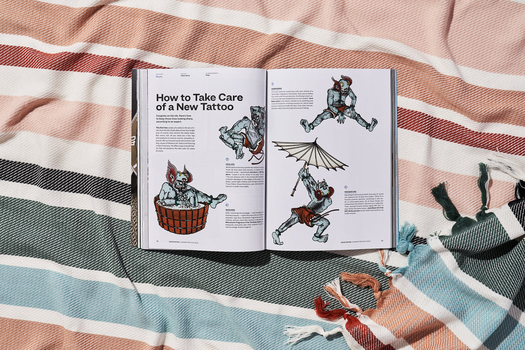 a copy of gear patrol magazine on a striped beach blanket open to the story How to Take Care of a New Tattoo with illustrations of a creature in various poses